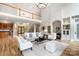Bright and spacious living room with hardwood floors, fireplace, wet bar, white sofas, and view of upper level at 3324 Greenhurst Dr, Matthews, NC 28104