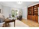 Inviting office space featuring a built-in bookcase, large window, neutral walls, and hardwood flooring at 3324 Greenhurst Dr, Matthews, NC 28104