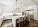 Elegant white kitchen features a marble island with seating and pendant lighting at 431 Wonderwood Dr, Charlotte, NC 28211