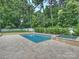 Beautiful backyard pool and spa area with stone pavers and a lush green perimeter at 431 Wonderwood Dr, Charlotte, NC 28211