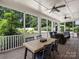 Inviting screened porch with wood floors, a dining table, and comfortable seating areas overlooking a yard at 431 Wonderwood Dr, Charlotte, NC 28211