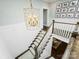 Classic staircase design with a decorative gold chandelier, white risers, and framed Gathering photos on the wall at 431 Wonderwood Dr, Charlotte, NC 28211