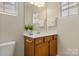 Well-lit bathroom featuring a single sink vanity with white countertop and wooden cabinetry at 44409 Oriole Dr # 200, Indian Land, SC 29707