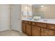 Bathroom with double sink vanity, wood cabinets, white countertops, and large mirrors at 44409 Oriole Dr # 200, Indian Land, SC 29707