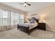 Bedroom with a large bed, side tables, ceiling fan, carpet and two windows at 44409 Oriole Dr # 200, Indian Land, SC 29707