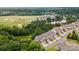 Overhead view of townhomes near a golf course, lush green trees, and a pond, showcasing community living at 44409 Oriole Dr # 200, Indian Land, SC 29707