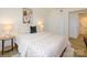 Bright bedroom featuring a bed with patterned bedding, bedside tables with lamps, and closet with folding doors at 4754 Hedgemore Dr # E, Charlotte, NC 28209