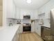 Bright, modern kitchen with updated stainless appliances, white cabinets, and quartz countertops at 4754 Hedgemore Dr # E, Charlotte, NC 28209