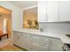 Open kitchen with white cabinets, quartz countertops, and stylish gold hardware at 4754 Hedgemore Dr # E, Charlotte, NC 28209