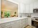 Bright kitchen features white cabinetry, modern appliances, and a pass-through to the living room at 4754 Hedgemore Dr # E, Charlotte, NC 28209