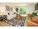 Comfortable living room featuring a modern rug, white sofa, and sliding glass doors to the outside at 4754 Hedgemore Dr # E, Charlotte, NC 28209