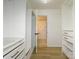 Spacious walk-in closet with custom shelving and storage solutions leading to an ensuite bathroom at 4754 Hedgemore Dr # E, Charlotte, NC 28209