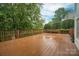 Spacious wooden deck is surrounded by lush greenery, offering a serene outdoor space at 506 Academy St, Mcadenville, NC 28101