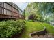 A landscaped backyard with a wooden deck, lush greenery, and a charming stone pathway at 506 Academy St, Mcadenville, NC 28101