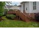 Wooden backyard deck showcasing lush greenery and stairs descending to the yard, perfect for outdoor enjoyment at 506 Academy St, Mcadenville, NC 28101