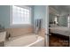 Relaxing bathtub area with a tile accent wall, window and view into the main bedroom at 506 Academy St, Mcadenville, NC 28101