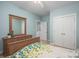 Bright bedroom featuring wood dresser with mirror and a bed with a blue and green comforter set at 506 Academy St, Mcadenville, NC 28101