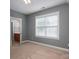 Light-filled bedroom featuring carpet floors, base molding, a window, and light-gray walls at 506 Academy St, Mcadenville, NC 28101