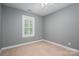 Neutral bedroom showcasing carpet floors, base molding, a window with shutters, and light-gray walls at 506 Academy St, Mcadenville, NC 28101