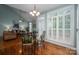 Well-lit dining area with hardwood floors, a glass table set, and an open view of the living room at 506 Academy St, Mcadenville, NC 28101