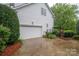 Exterior of the garage with a concrete driveway, some landscaping, and a backyard gate at 506 Academy St, Mcadenville, NC 28101