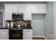 This kitchen features white cabinets, granite countertops, and modern stainless-steel appliances at 506 Academy St, Mcadenville, NC 28101