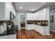 This kitchen features white cabinets, hardwood floors, and granite countertops at 506 Academy St, Mcadenville, NC 28101