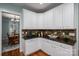 This kitchen features white cabinets, granite countertops, and hardwood floors at 506 Academy St, Mcadenville, NC 28101