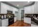 This kitchen features white cabinets, granite countertops, and modern stainless-steel appliances at 506 Academy St, Mcadenville, NC 28101