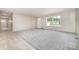 The home's living room offers neutral carpet, a front door, and two large windows that bring in lots of light at 5090 Beaver Dam Way, Bessemer City, NC 28016