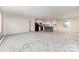 Open-concept living area featuring gray carpet, with kitchen including island and laminate flooring at 5090 Beaver Dam Way, Bessemer City, NC 28016