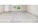 An open living room offers neutral carpet and two large windows that bring in lots of natural light at 5090 Beaver Dam Way, Bessemer City, NC 28016