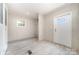 A spacious room with tile floors and a door to the outside is naturally lit by a window at 5090 Beaver Dam Way, Bessemer City, NC 28016