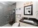 Modern bathroom with grey tiled shower, toilet, and sleek vanity with dark countertop at 524 Heritage Vw, Indian Trail, NC 28079