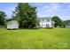 Spacious backyard featuring a shed, expansive green lawn, and the rear of a two-story white house at 6516 Laurel Springs Ct, Charlotte, NC 28227