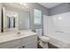 This bathroom features a tub, toilet and vanity with a grey wall and a door out to a bedroom at 6516 Laurel Springs Ct, Charlotte, NC 28227