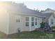 Exterior view showcasing the home's siding, windows, and small patio, highlighting the backyard at 6902 Vernon Wood Ln, Charlotte, NC 28262