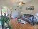 View of the living room featuring hardwood floors, a ceiling fan, a neutral color scheme, and comfortable seating at 6902 Vernon Wood Ln, Charlotte, NC 28262