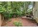 Landscaped backyard featuring a stone patio, hammock, and lush greenery for outdoor enjoyment at 6935 Woodstock Dr, Charlotte, NC 28210