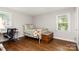 Bedroom with hardwood flooring, neutral paint, and two brightly lit windows at 6935 Woodstock Dr, Charlotte, NC 28210