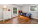 Bright bedroom with hardwood floors, a white dresser and dual windows at 6935 Woodstock Dr, Charlotte, NC 28210