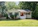 Charming one-story home features a freshly cut lawn and a bright red front door at 6935 Woodstock Dr, Charlotte, NC 28210