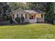 Charming one-story home features a freshly cut lawn and a bright red front door at 6935 Woodstock Dr, Charlotte, NC 28210
