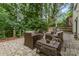 Cozy brick patio with outdoor seating, fire pit, and lush greenery, perfect for relaxing outdoors at 6935 Woodstock Dr, Charlotte, NC 28210