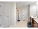 Neutral bathroom showcases a glass-enclosed shower, tile flooring, and convenient linen storage at 7263 Waterwheel Sw St, Concord, NC 28025