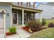 Cozy porch enhanced by manicured landscaping, creates an inviting entrance at 7263 Waterwheel Sw St, Concord, NC 28025