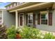 Charming covered porch seating area, enhanced by lush landscaping, creates an inviting entryway at 7263 Waterwheel Sw St, Concord, NC 28025