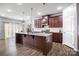 Gourmet kitchen with granite counters, center island and wood cabinetry at 7263 Waterwheel Sw St, Concord, NC 28025
