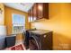 Organized laundry room features modern appliances, ample cabinet space, and bright window views at 7263 Waterwheel Sw St, Concord, NC 28025