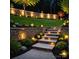 A beautifully landscaped backyard featuring stone stairs, garden beds with lights, and lush green lawn at 7810 Leisure Ln, Huntersville, NC 28078